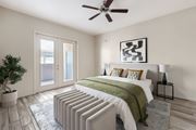 Tucson apartment for rent - A bedroom with a bed, pillows, a ceiling fan, and a plant.