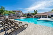 Tucson apartment for rent - Resort-Style swimming pool surrounded by lounge chairs and umbrellas