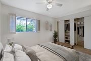Tucson apartment for rent - A bedroom with a large bed and a closet with clothes.