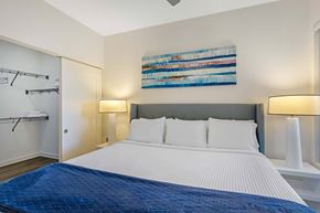 Chamblee apartment for rent - A bedroom with a large bed and a painting on the wall.