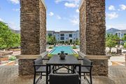 Land O Lakes apartment for rent - A table with chairs is in the foreground of a pool area.