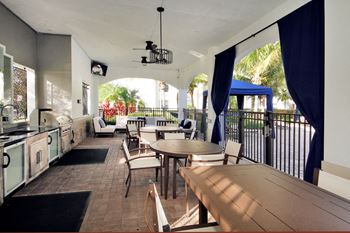 Poolside summer kitchen with grills and tables and chairs