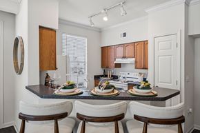 Fort Myers apartment for rent - A kitchen with a table set for two with a white chair on either side.