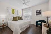 Fort Myers apartment for rent - A bedroom with a bed, chair, and artwork on the wall.