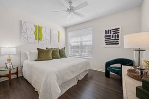 Fort Myers apartment for rent - A bedroom with a bed, chair, and artwork on the wall.