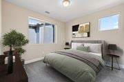 Colorado Springs apartment for rent - A bedroom with a bed, nightstand, and a plant.