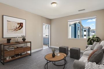 Colorado Springs apartment for rent - A living room with a grey sofa, a coffee table, and a painting on the wall.