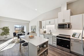 Rochester apartment for rent - A modern kitchen with white cabinets and a large island.at SoRoc On Maine, Minnesota, 55904