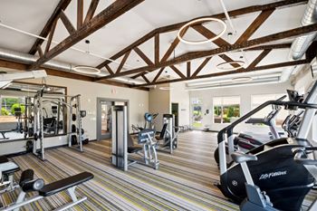 A gym with a variety of equipment including treadmills, weights, and exercise machines.