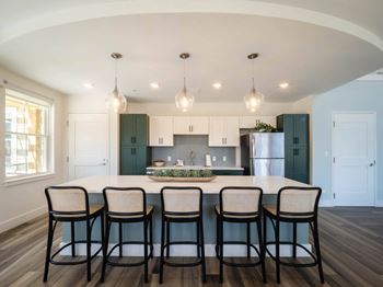 A clubroom kitchen with green cabinets and stainless steel appliances