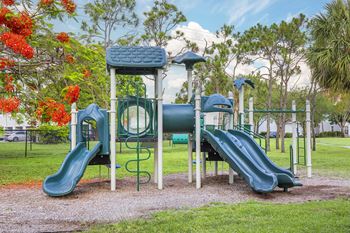 A playground with a green slide and a blue and green play structure