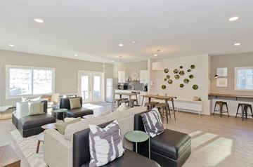 Edmonton apartment for rent - A modern living room with a black leather sofa and a wooden coffee table.