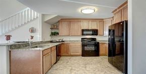 Lancaster apartment for rent - a kitchen with wooden cabinets and black appliances