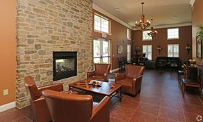 Albany apartment for rent - A living room with a stone fireplace and brown leather chairs.