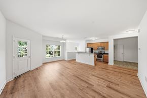 Albany apartment for rent - A spacious room with wooden flooring and white walls.
