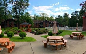 Queensbury apartment for rent - a patio with tables and benches in front of a building