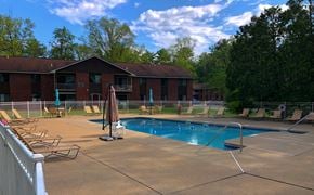 Queensbury apartment for rent - a swimming pool in front of a red brick building
