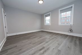 Philadelphia apartment for rent - an empty living room with wood flooring and two windows