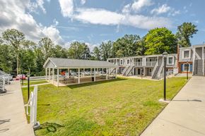 Morganton apartment for rent - A sunny day at a park with a building and a picnic table.