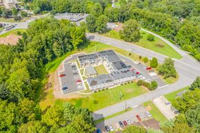Morganton apartment for rent - An aerial view of a parking lot with cars and a building in the background.