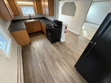 Concord apartment for rent - A kitchen with wooden cabinets and black appliances.