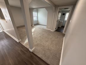 Concord apartment for rent - A spacious room with a carpeted floor and wooden flooring.