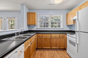 Shelby apartment for rent - A kitchen with wooden cabinets and a white refrigerator.