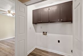 Greenville apartment for rent - A white wall with a brown cabinet and a ceiling fan.