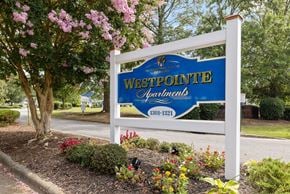 Greenville apartment for rent - A sign for Westpointe Apartments is displayed in front of a tree with pink flowers.