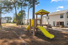 Wilmington apartment for rent - A playground with a yellow slide and a yellow and brown wooden structure.
