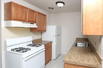 Clinton Twp apartment for rent - a kitchen with white appliances and granite counter tops and a white refrigerator