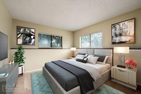 Topeka apartment for rent - A bedroom with a large bed and a potted plant.