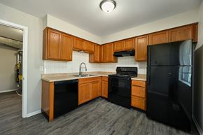 Topeka apartment for rent - A kitchen with black appliances and wooden cabinets.
