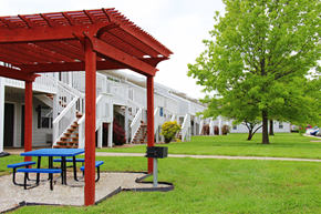Lawrence apartment for rent - A red pergola is in front of a white building.
