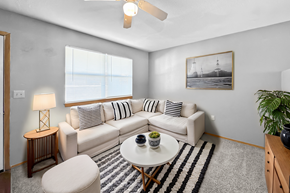 Lawrence apartment for rent - A living room with a white couch, a small table, and a ceiling fan.
