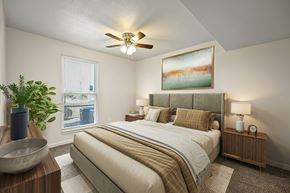 Topeka apartment for rent - A bedroom with a large bed and a ceiling fan.