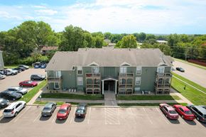 Topeka apartment for rent - A parking lot with cars and a building in the background.