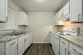 Topeka apartment for rent - A kitchen with white cabinets and a granite countertop.