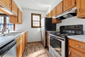 Topeka apartment for rent - a kitchen with stainless steel appliances and wooden cabinets