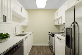 Topeka apartment for rent - A kitchen with white cabinets and stainless steel appliances.