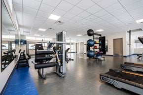 Winnipeg apartment for rent - A gym with treadmills, weights and exercise equipment.