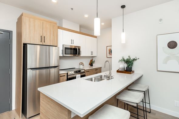 Winnipeg apartment for rent - A modern kitchen with a stainless steel refrigerator and a white countertop.