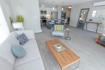 Regina apartment for rent - A modern living room with a white couch and a wooden coffee table.