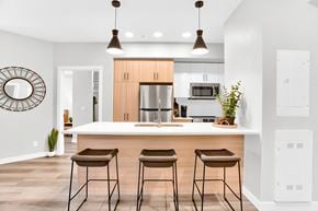 Calgary apartment for rent - Modern kitchen with white countertops and bar seating at Plaza Apartments, Calgary, AB T2L 2M8