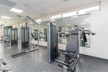 A gym with a variety of equipment including treadmills, stationary bikes, and weight machines.