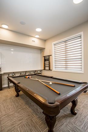 Regina apartment for rent - A pool table with a brown cloth and two pool cues.