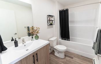 A white sink with a black towel on the counter.