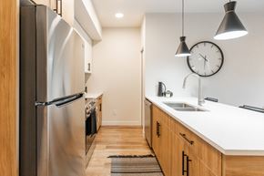 Edmonton apartment for rent - A Kitchen With a Refrigerator at Cadence at Griesbach, Edmonton, T5E 1Y8