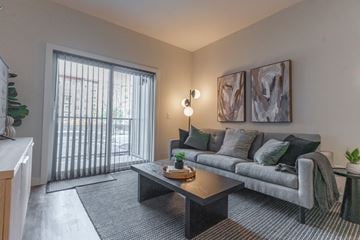 Edmonton apartment for rent - A living room with a grey couch, a coffee table, and two framed pictures on the wall.