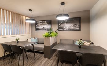 A modern dining area with a table, chairs, and a couch.